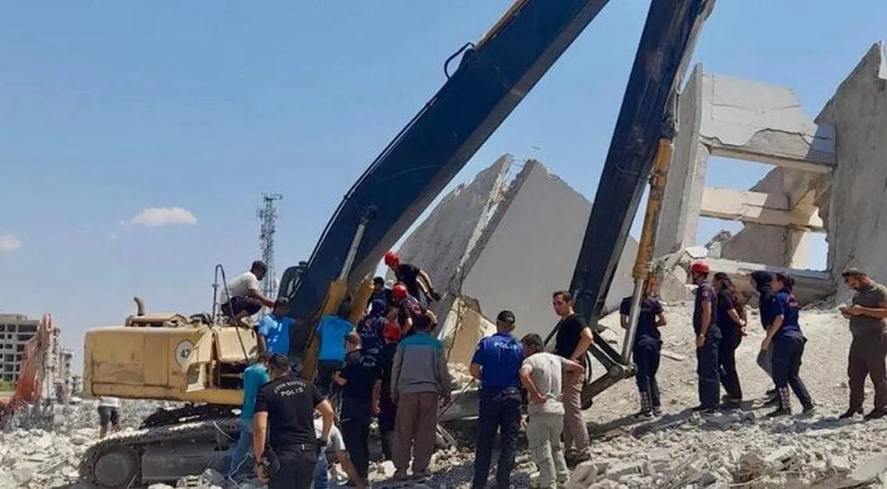 Hasarlı bina ekskavatörün üzerine yıkıldı