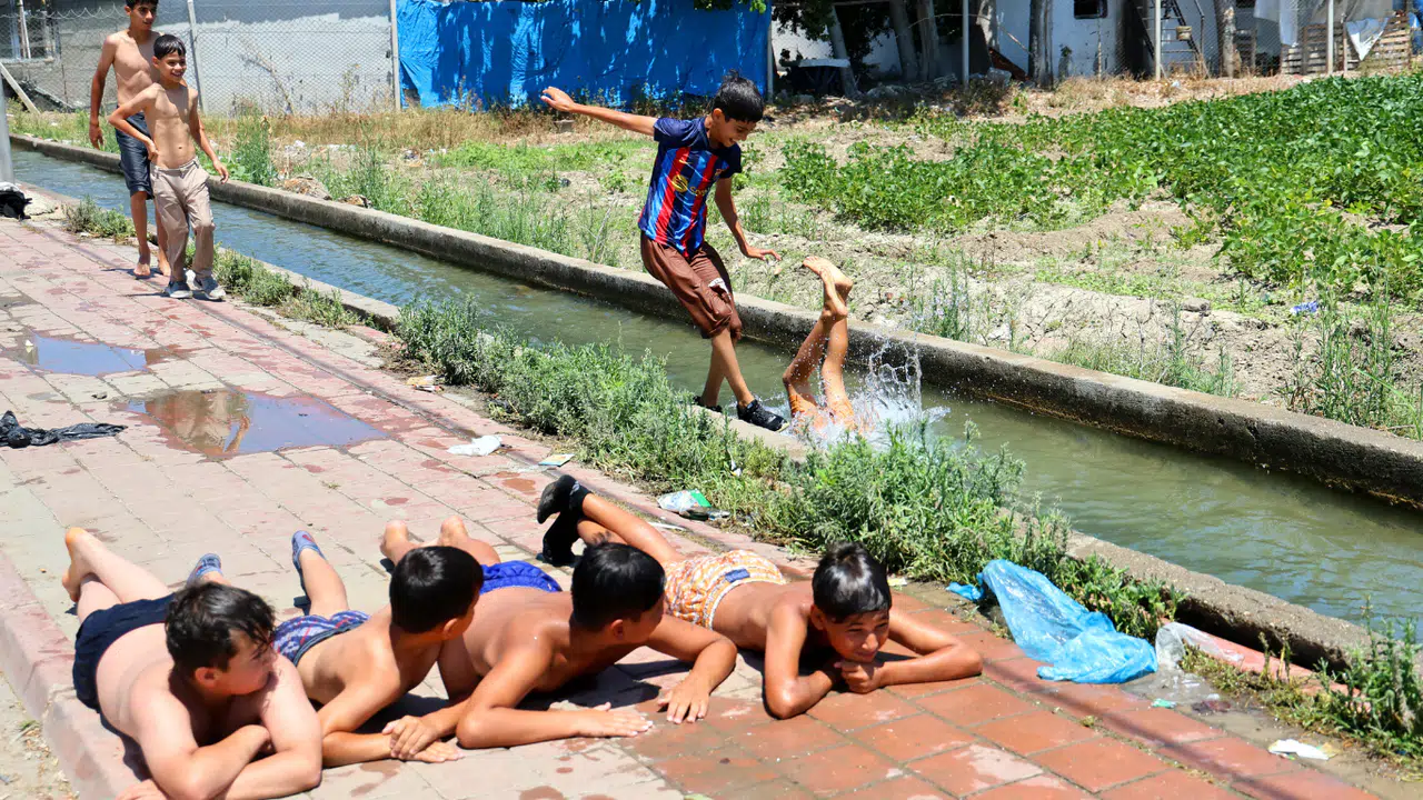 Çocukların Yaz Tatili: Kanaletlerde Yüzüyor, Kaldırımda Güneşleniyorlar