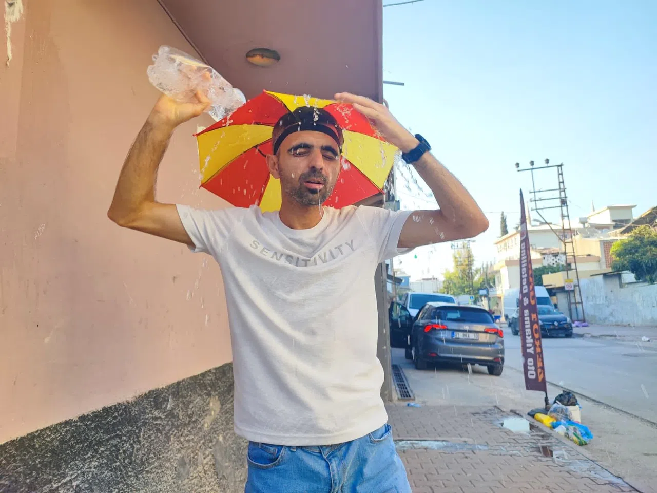 Aşırı Sıcaklar Nedeniyle Kafasına Taktığı Şemsiye İle Geziyor