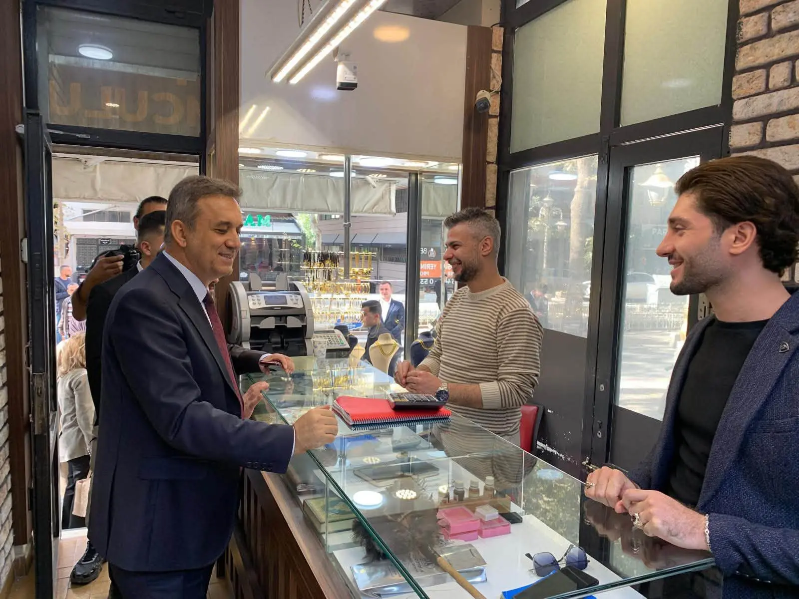 bir veya daha fazla kişi, takım elbise, kol saati ve yazı görseli olabilir